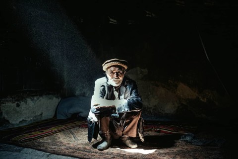 Man sitting on a carpet in his house