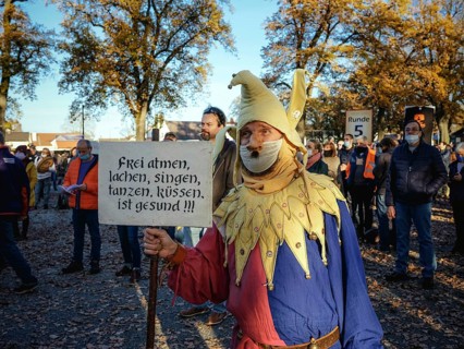 A man dressed as a joker with a Hitler beard