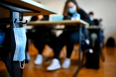 Face mask hangs on school desk