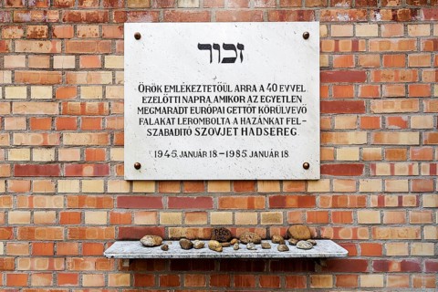 Memorial plaque commemorating the liberation of the Jewish ghetto on a wall of red bricks