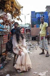 Bride sitting in front of a market stall