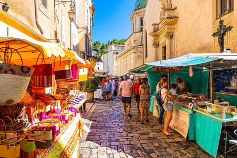 Tourists strolling through the stalls at the weekly market market in Apt
