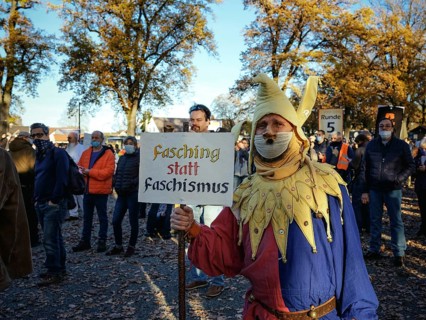 A man dressed as a joker with a Hitler beard