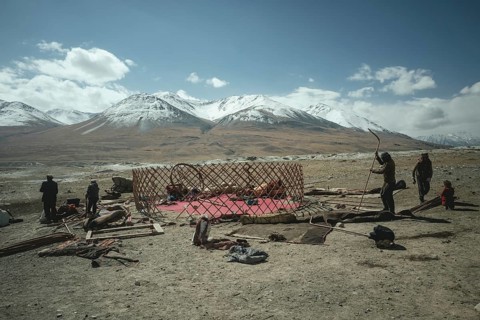 Four men dismantling a yurt