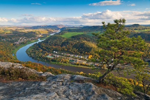 View from the autumnal Lilienstein with Wetterkiefer on the Elbe river near Koenigstein to Bad Schandau and over the German-Czech border with Mount Ruzova