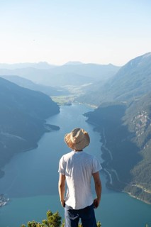Young man looks over mountain landscape