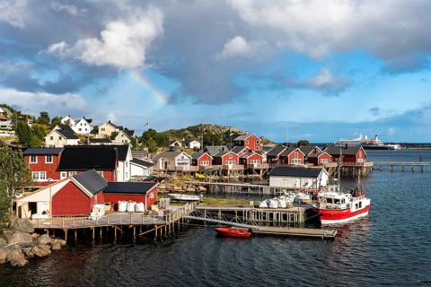 Rainbow over Rorbuer cabins in Reine