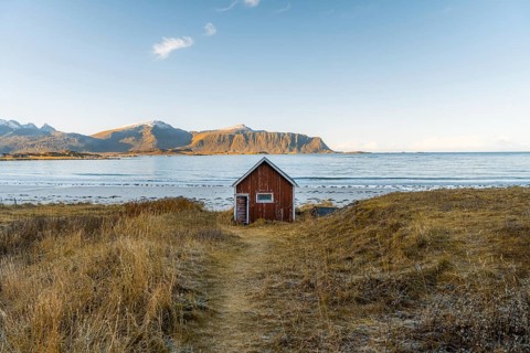 Red cabin in front of Ramberg beach at sunset