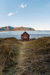 Red cabin in front of Ramberg beach at sunset