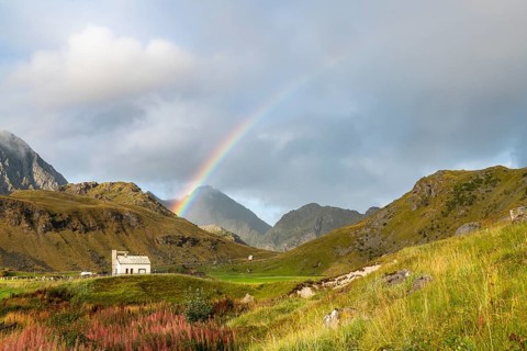 Chapel with rainbow in the mountains of Lofoten