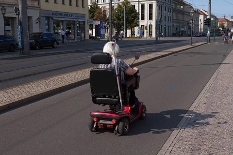 Older lady in a wheelchair on a bicycle path