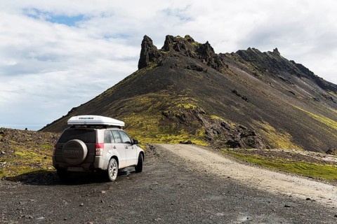 All-terrain vehicle with roof tent next to gravel road on Stapafell mountain