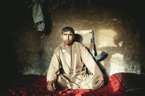 Man sitting on a mattress on the floor in a house