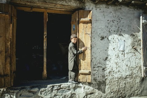 Boy looks out an open double door