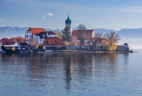 Peninsula with the parish church of St. George in front of the Alps