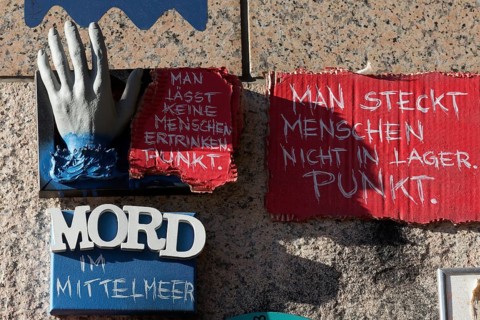 Outstretched hand and writing Murder in the Mediterranean Sea