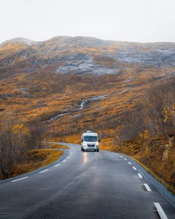 Campervan on a road with autumnal vegetation