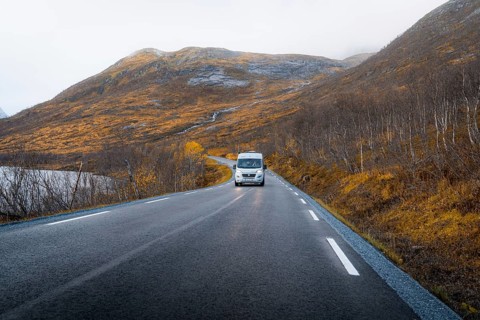 Campervan on a road with autumnal vegetation
