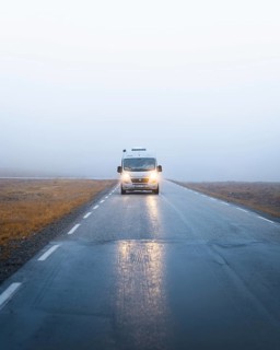 Campervan with bright lights on a road near the North Cape