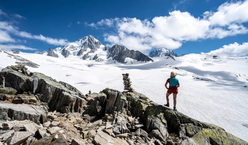 Hiker standing in front of glacier