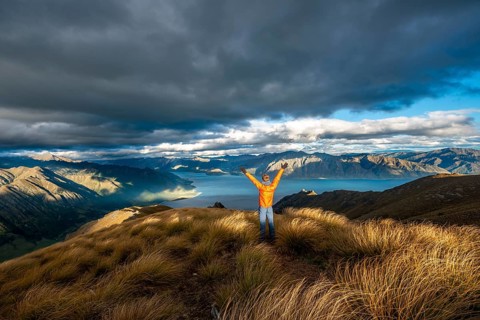 Hiker stretches his arms in the air