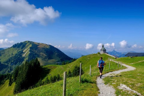 Hiker in front of the Wallberg church Heilig Kreuz