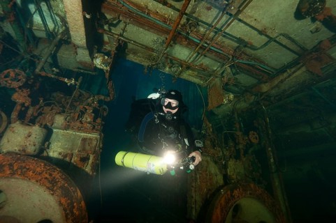 Tech diver with special equipment in shipwreck