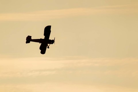 Fairey Swordfish aircraft in flight at sunset in Royal Navy markings