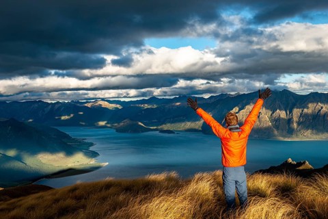 Hiker stretches his arms in the air