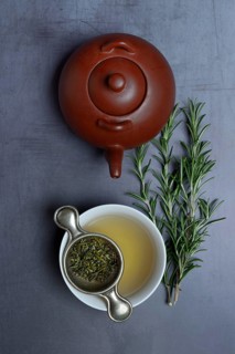 A cup of rosemary tea with tea strainer