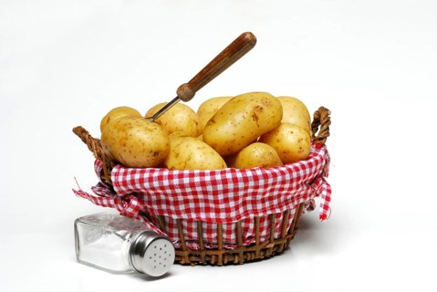 Jacket potatoes in basket and salt shaker