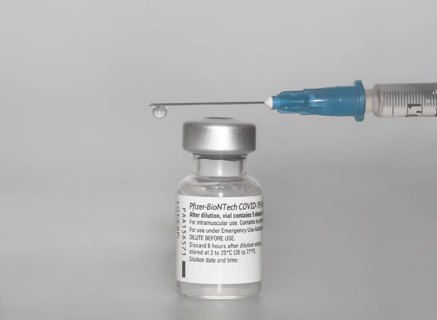 Vaccine vial against Covid 19 and syringe with drops