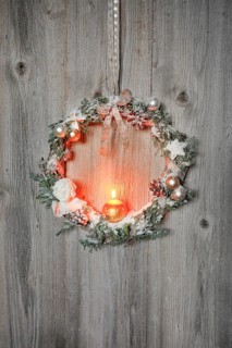 Christmas wreath on wooden wall with candle