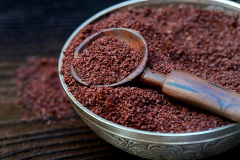 Sumac powder in bowl and spoon
