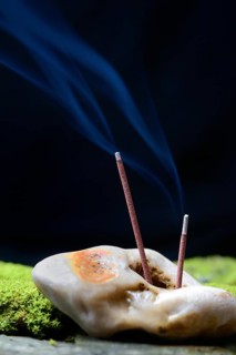 Burning incense sticks stuck in stone