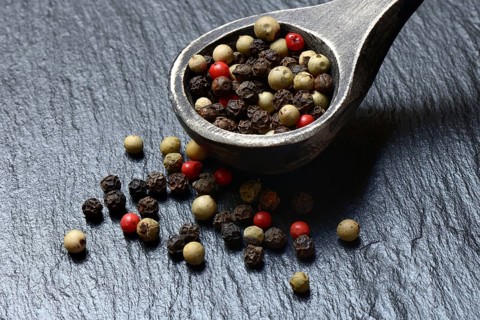 Peppercorns in wooden spoon