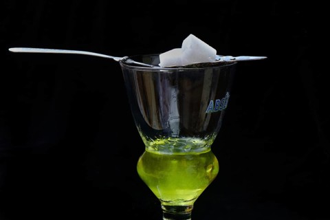 Glass of absinthe with absinthe spoon and sugar cubes