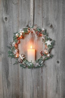 Christmas wreath on wooden wall with candle
