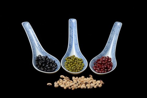 Various dried beans in porcelain spoon