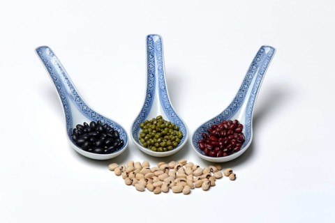 Various dried beans in porcelain spoon