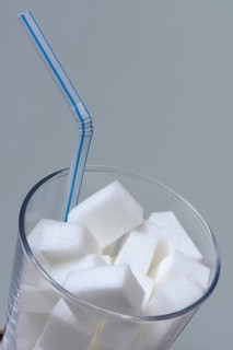 Sugar cubes in drinking glass with straw