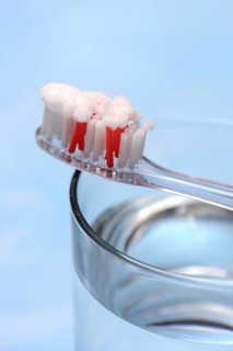 Sodium powder on toothbrush and glass with water