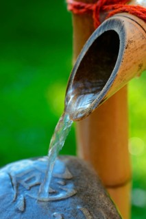 Japanese bamboo fountain and stone with inscription