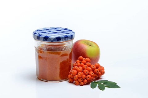 Glass of rowanberry and apple jam with n