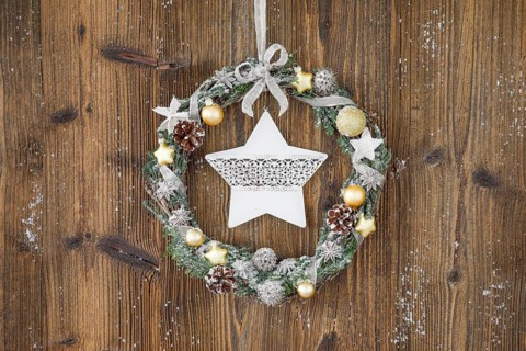 Christmas wreath on brown wooden wall with star