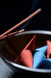 Incense cones in bowl and burning incense sticks