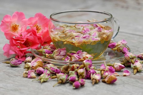 Rose tea in cup and rose buds