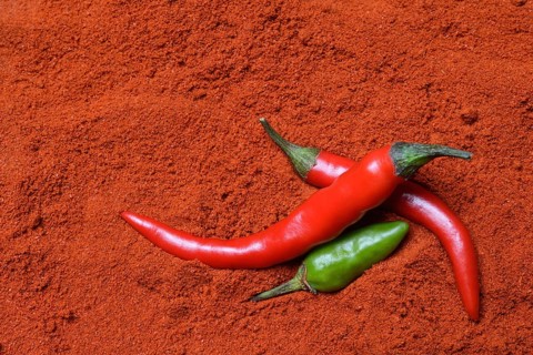 Red and green chilli peppers in chilli powder