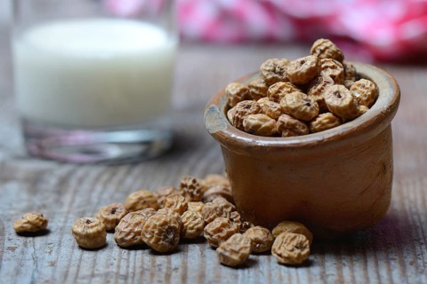 Tigernuts in pot and glass of milk