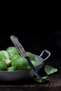 Brussels sprouts in bowl with kitchen knife